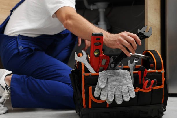 A man holding a tool bag filled with various tools, ready for plumbing and handyman services in Pembroke Pines FL